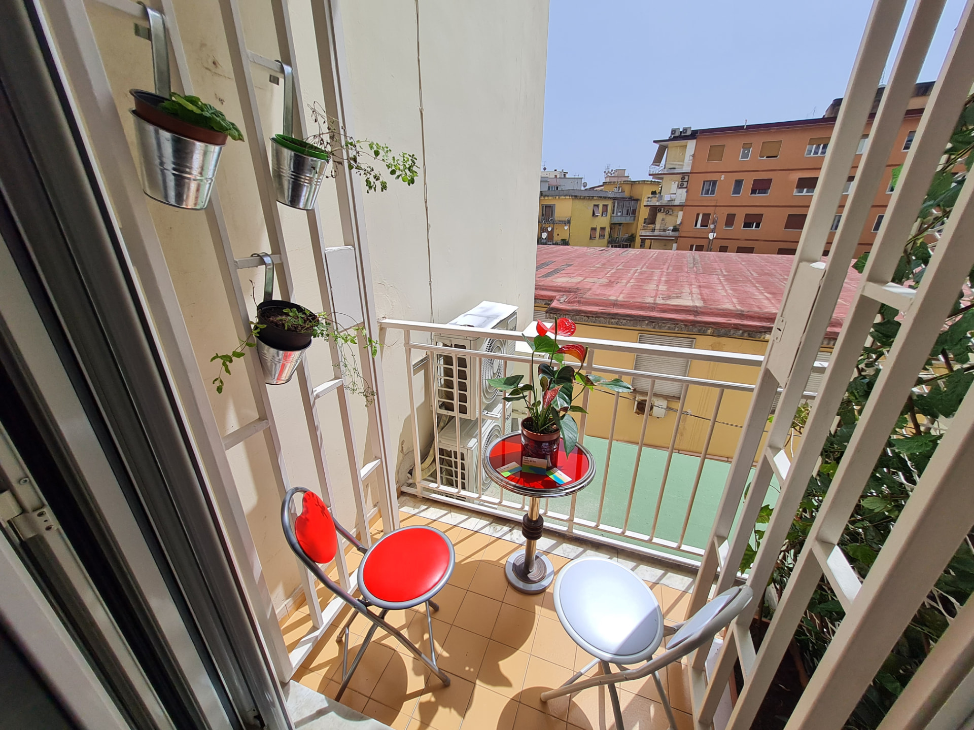 Terrazzo con sedie colorate e vista città