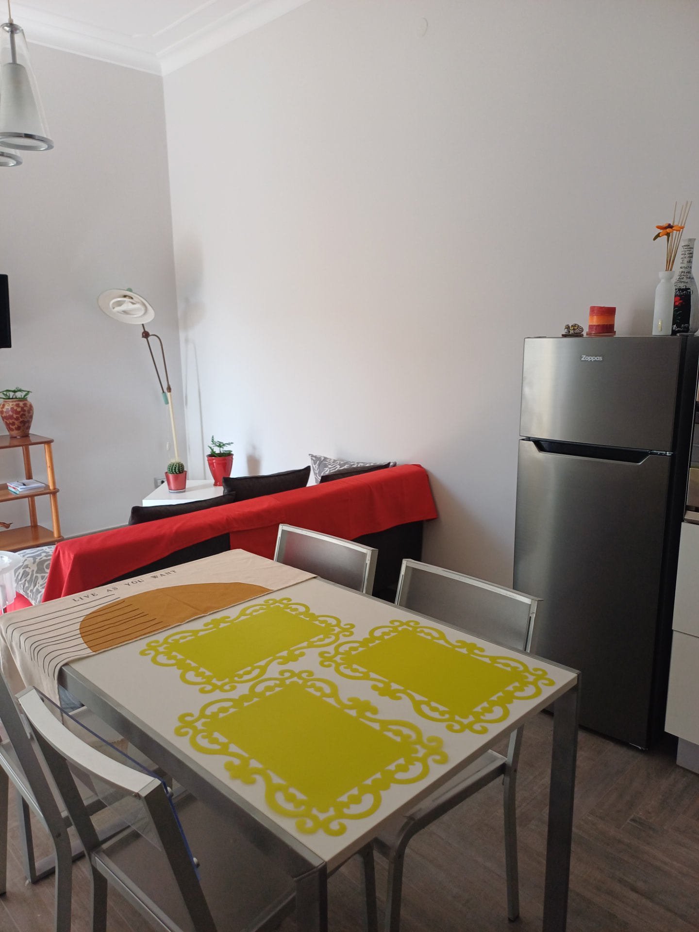 Tavolo da pranzo con frigorifero e divano sullo sfondo